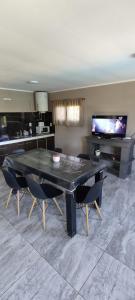 a dining room with a black table and chairs at arrayanes in Junín