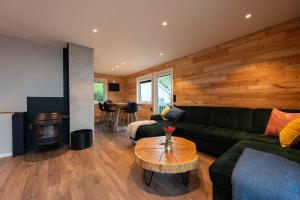 a living room with a green couch and a table at Lofoten Green House in Ramberg