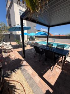 a patio with a table and chairs and a pool at Luxury Blue Sky in Vir +124 photos