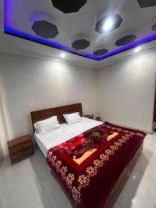 a bedroom with a large bed with a red blanket at Regal Heights in Bhurban