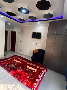 a room with a bed with a red carpet and a tv at Regal Heights in Bhurban