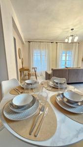 a table with plates and silverware on top of it at Carte Postale Trikeri in Trikeri