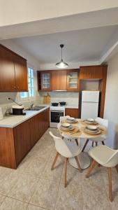 a kitchen with a table and two chairs and a table at Carte Postale Trikeri in Trikeri +3 photos