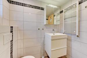 a white bathroom with a sink and a mirror at Villa Arkodes in Gdańsk