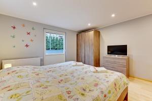 a bedroom with a large bed and a television at Villa Arkodes in Gdańsk