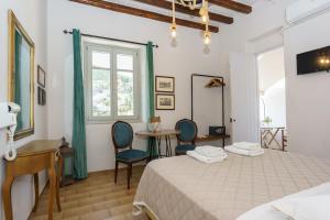 a bedroom with a bed and a desk and chairs at Athina Guesthouse in Hydra