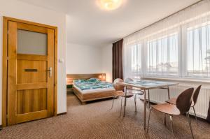 a room with a table and chairs and a bed at Złota 24 in Karwia