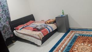 a bedroom with a bed with a dresser and a rug at Mohammad hostel in Ma‘ābīlah