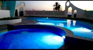 a large blue swimming pool with lights in a building at Hergla Diamond Kais in Sousse