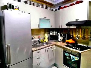 a kitchen with a white refrigerator and a sink at Hergla Diamond Kais in Sousse