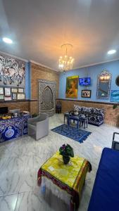 a large living room with blue walls and a chandelier at Dar Bouanani in Asilah