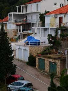 a house with a blue tarp on top of it at Apartment Riva Lastovo in Ubli +6 photos