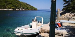 a boat tied to a dock in the water at Apartment Riva Lastovo in Ubli