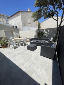 a patio with a table and chairs and a tree at T2 avec terrasse privative Berre-l'Étang in Berre-lʼÉtang