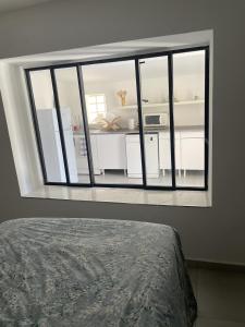 a bedroom with a large window in a room at T2 avec terrasse privative Berre-l'Étang in Berre-lʼÉtang