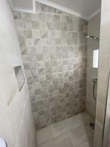 a bathroom with a shower with a tiled wall at T2 avec terrasse privative Berre-l'Étang in Berre-lʼÉtang +5 photos