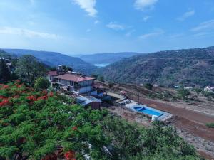 a house on a hill with a swimming pool at Nature's Glory Resort in Panchgani