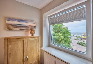 a room with a window with a view of the ocean at Haus Schildt, FeWo 5 in Duhnen