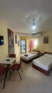 a bedroom with two beds and a table and chairs at Dar Bouanani in Asilah