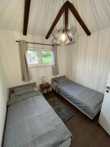 a bedroom with two beds and a chandelier at Villa Noor Visoko in Visoko