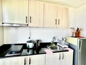 a kitchen with white cabinets and a sink at SMDC Wind Residences Condo Unit by Bil & J's in Kaybagal