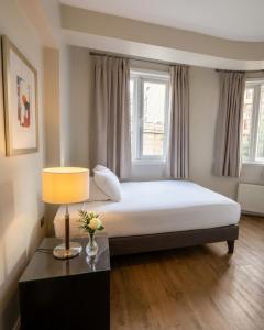 a bedroom with a bed with a lamp and a window at Lastarria Aparts in Santiago