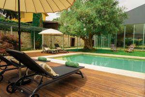 a deck with a chair and a swimming pool at Estrepão House in Moreira de Conegos
