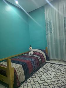 a bedroom with a bed with a blue wall at Ayem house in Souidania +4 photos
