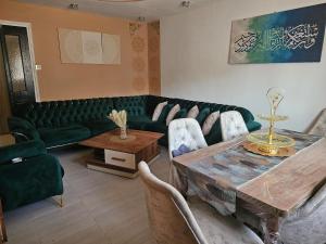 a living room with a green couch and a table at Ayem house in Souidania