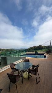 a patio with a table and chairs on a roof at Refúgio com Piscina e Vista Deslumbrante in Caconde
