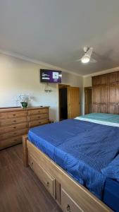 a bedroom with a large bed with a blue comforter at Refúgio com Piscina e Vista Deslumbrante in Caconde +15 photos