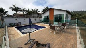 a patio with a pool and a table and chairs at Refúgio com Piscina e Vista Deslumbrante in Caconde