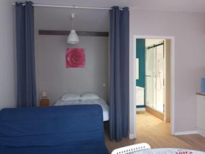 a bedroom with a blue couch and a bed at Studio à louer in Vic-Fezensac