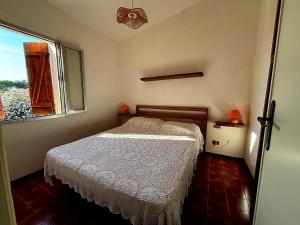 a small bedroom with a bed and a window at Casa Pineta in Rena Majore