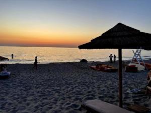 a group of people on a beach with an umbrella at Casa Pineta in Rena Majore