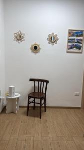 a wooden chair in a room with a white wall at Casa della nonna in Pescara +2 photos