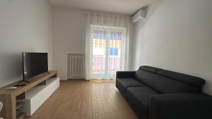 a living room with a black couch and a television at Casa della nonna in Pescara
