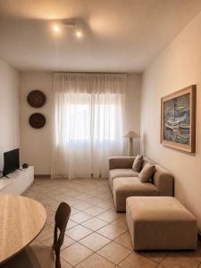 ein Wohnzimmer mit Sofa und Tisch in der Unterkunft Ā - Living in Valledoria