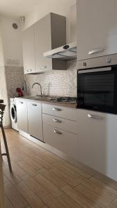 a kitchen with white cabinets and a stove top oven at Casa della nonna in Pescara