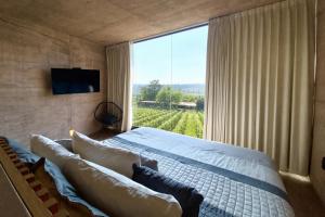 a bedroom with a bed and a large window at Hacienda Lagunillas in Querétaro