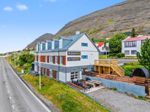 a building on the side of a road next to a hill at Hotel West in Patreksfjörður