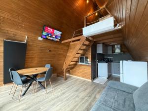 a room with a table and chairs and a kitchen at A-Frame The Wolf Transfăgărășan in Căpăţîneni-Ungureni