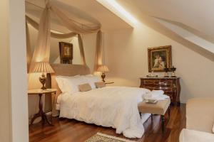 a bedroom with a large white bed with two lamps at Estrepão House in Moreira de Conegos +28 photos