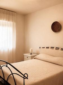 ein Schlafzimmer mit einem großen Bett und einem Fenster in der Unterkunft Ā - Living in Valledoria