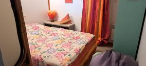 a bedroom with a bed with a floral bedspread at Chalet La Caz'à Joooh in Rivières