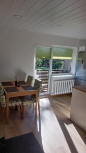 a dining room with a table and two windows at Mugav mereäärne korter in Orissaare