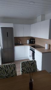 a kitchen with white cabinets and a table with chairs at Mugav mereäärne korter in Orissaare +3 photos