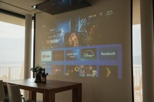 a projection screen on a wall with a wooden table at Villa Horizon in Torri del Benaco