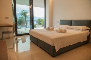 a bedroom with a bed with two towels on it at Villa Horizon in Torri del Benaco +35 photos