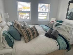 a white bed with pillows on it in a bedroom at Coastal Charm Seaside House in Moelfre